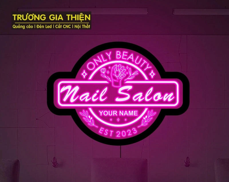 Bảng hiệu nail màu hồng pastel nổi bật trước cửa tiệm.